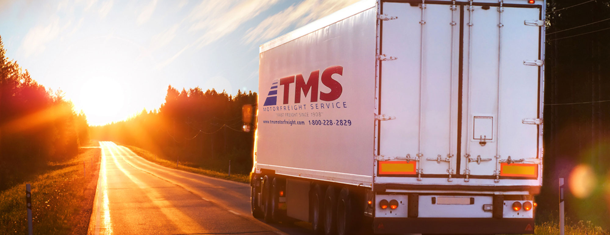 Semi truck and trailer driving into the sunset on a rural highway